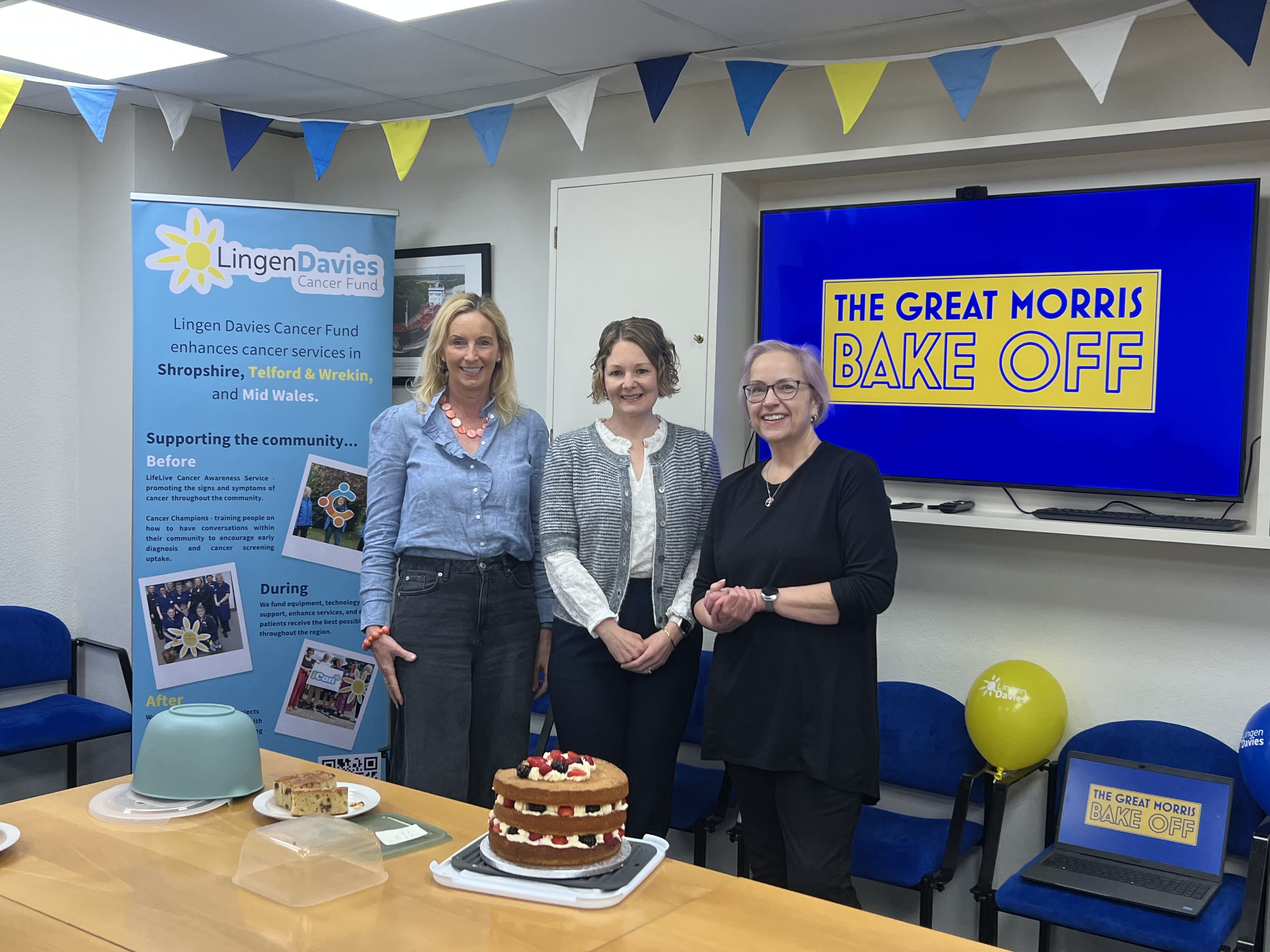 Morris Lubricants charity bake off winner with the judges and her cake 